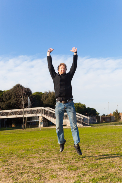 Young Man Jumping Outdoor Laughing - Фото, зображення