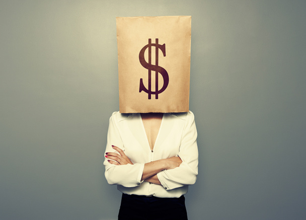 γυναίκα κρύβονται κάτω από το χαρτί τσάντα με το σύμβολο του δολαρίου - Φωτογραφία, εικόνα