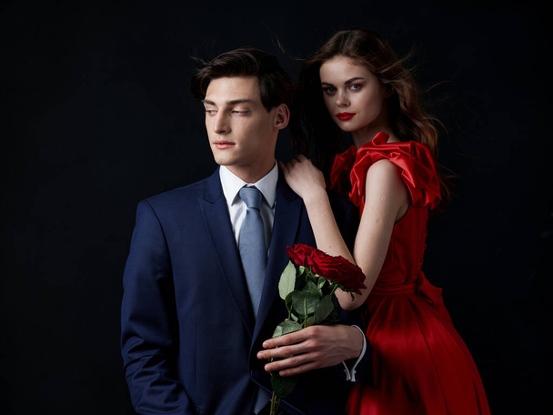 un jeune couple portrait luxe romance fleurs sombre fond - Photo, image