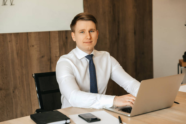Successful businessman working at a laptop in his office, office work. High quality photo - Fotografie, Obrázek