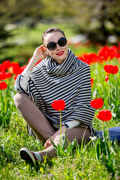Beautiful woman in spring park among tulip field - Photo, Image