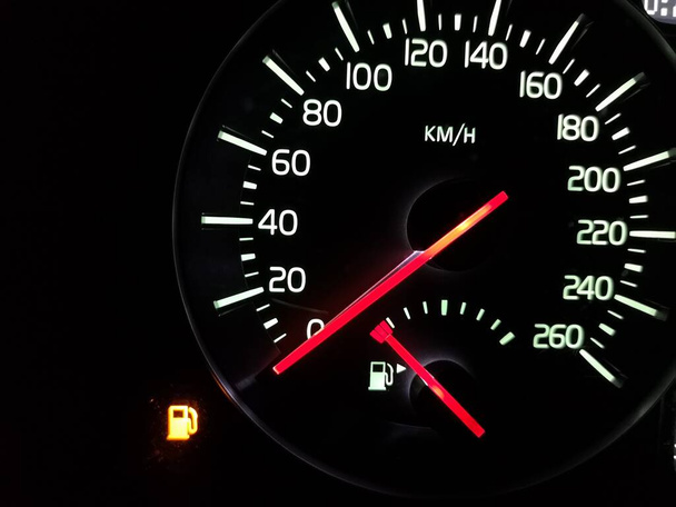 空のタンク。矢印がゼロの速度計。燃料が尽きた。危機だ。車は行きません。速度0 。車のダッシュボード。赤い矢印でダイヤルします。照明付きのナイトデバイス。緊急給油が必要だ. - 写真・画像