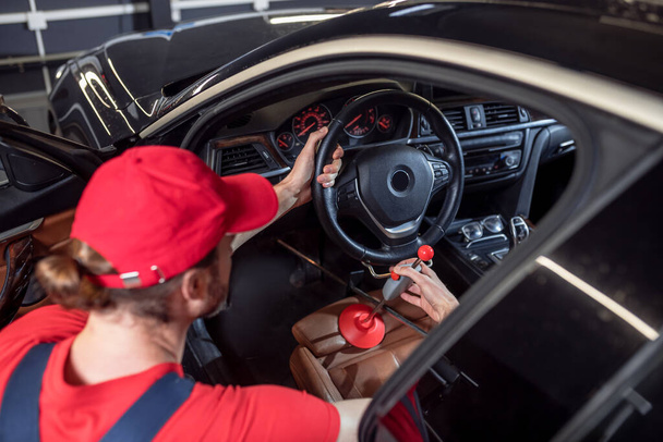 Car service worker adjusting steering wheel in car - Fotografie, Obrázek