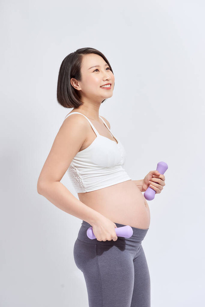 Terhes nő tréning súlyzókkal - Fotó, kép
