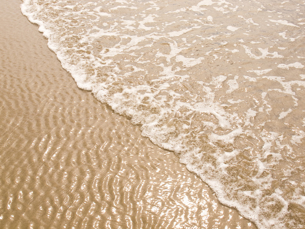 schäumende Meeresküste an einem sonnigen Strand - Foto, Bild