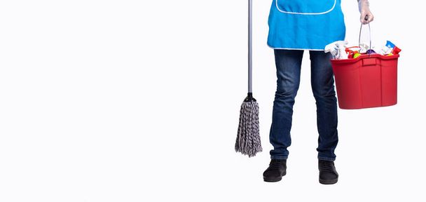 Banner, long format over white background with plenty space for your advertisement. Cropped photo of man body in apron with cleaning products in red bucket and wet mop. Only male feet wearing jeans - Foto, Imagen