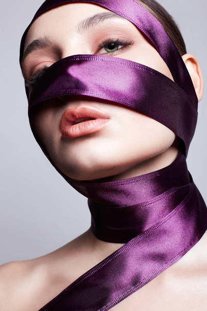 beautiful young woman in silk ribbon on her face and body. beauty portrait of pretty Girl - Foto, immagini