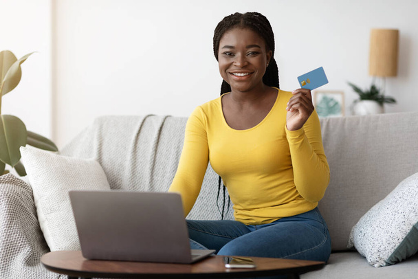 Online fizetés. Fekete nő gazdaság hitelkártya és a laptop használata otthon - Fotó, kép
