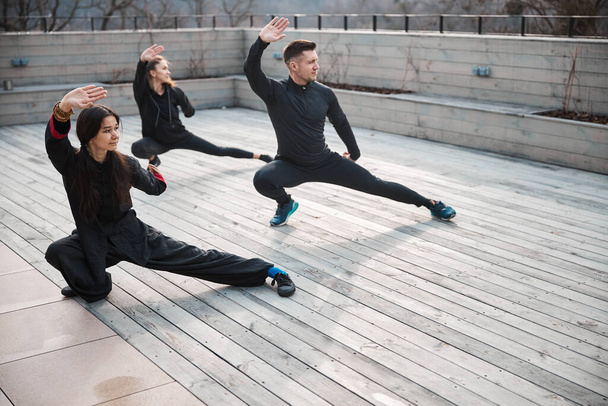Tai chi training of a group outdoors on roof - Photo, Image