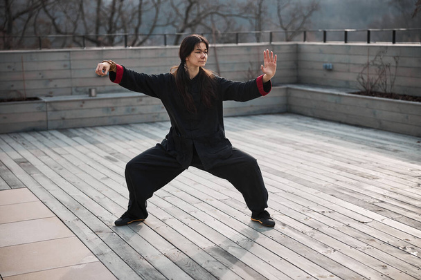 Female taijiquan exercise holding opened hand before herself - Foto, imagen