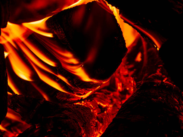 Brennholz im ländlichen Ofen verbrennen. Rot-orangefarbene Flamme eines Holzofens im Dunkeln. Gemütlich heiße Kaminfeuer Verbrennung in der Nacht. Helle warme Bildschirmschoner Tapete Restaurant Pizzeria Kohlenbecken Grill - Foto, Bild