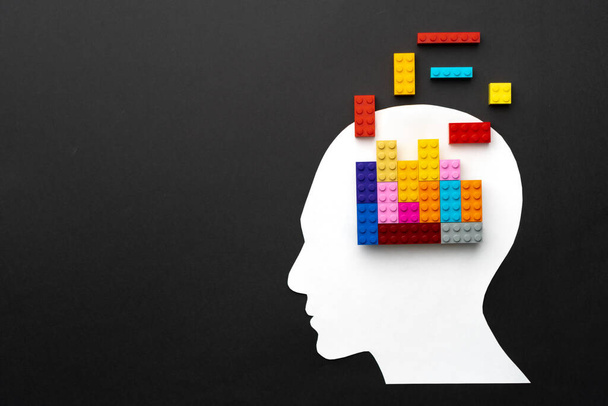 Papercut silhouette of human head with colorful constructor pieces - Foto, afbeelding