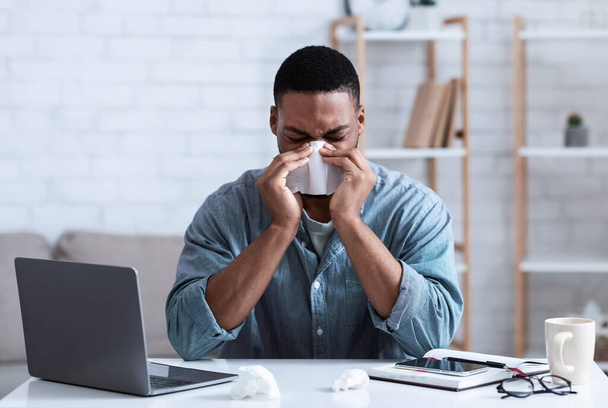 Sick Black Guy Blowing Nose In Napkin Working In Office - Photo, Image