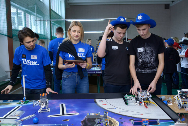 Young people adjusting robot before launching it. School tournament among pupils. January 9, 2019. Kiev, Ukraine - Zdjęcie, obraz