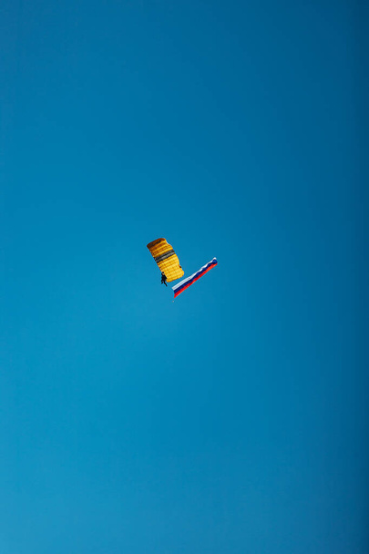 mezi stromy se chystá přistát parašutista v nízké výšce. nebezpečný extrémní sport skákání z létajícího letadla - Fotografie, Obrázek