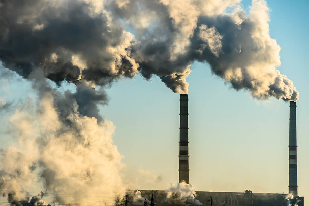 Kouřící tovární komíny s emisemi CO 2. Environmentální problém znečištění životního prostředí.Změna klimatu, ekologie, globální oteplování.Obloha je zakouřená jedovatými látkami.Saze z továren - Fotografie, Obrázek