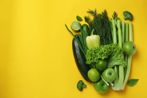 Fresh green vegetables on yellow background, space for text - Photo, Image