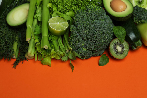 Čerstvá zelená zelenina na oranžovém pozadí, prostor pro text - Fotografie, Obrázek
