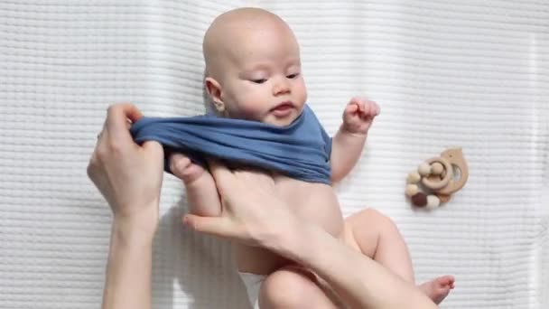 Mütter Hände, die sich ausziehen oder ausziehen Babys Hemd Anzug von oben Ansicht - Filmmaterial, Video