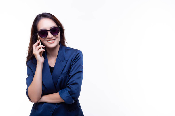 Mujer de negocios hermosa feliz usando soporte de teléfono inteligente sobre aislado en el espacio de copia de fondo blanco Joven chica de negocios usar gafas de sol Moda de traje azul - Foto, imagen