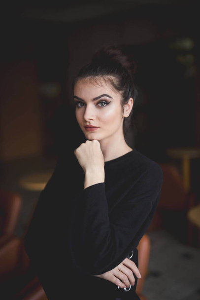 A young Bosnian woman with a bun hairstyle and serious face - Foto, Bild
