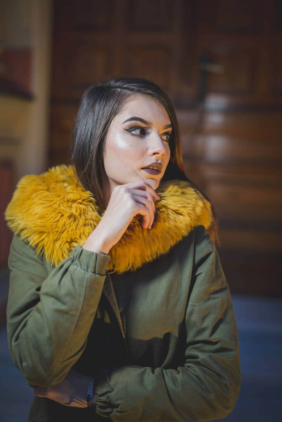 An attractive brown hair Caucasian female in a winter jacket posing at camera - Foto, Bild