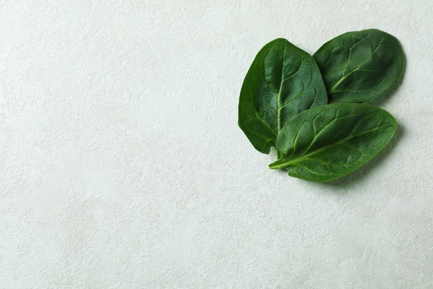 Свіже листя шпинату на білому фактурному фоні
 - Фото, зображення