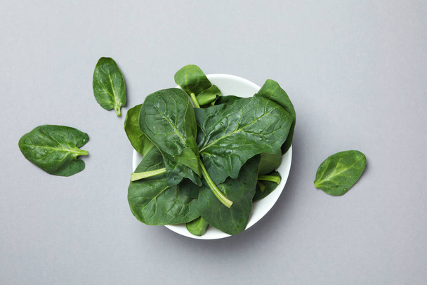 Bowl of spinach leaves on light gray background - Fotografie, Obrázek