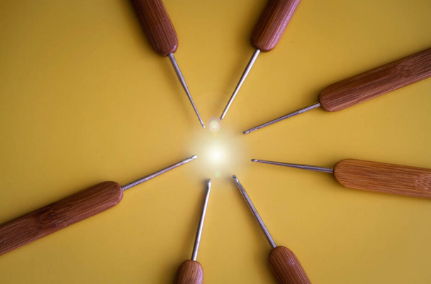 Closeup head of Crochet Hooks point to circle light at the middle of background,Lens flare effect - Foto, imagen