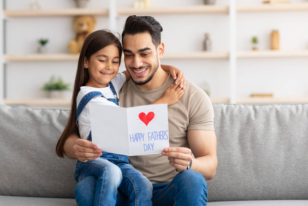 Happy little daughter greeting young dad with card - Photo, Image