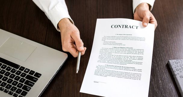 Podnikatel předává smlouvu na podpis a v ruce drží kuličkové pero. - Fotografie, Obrázek