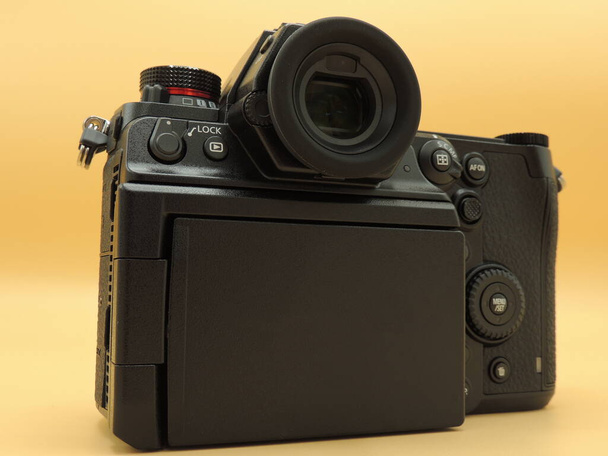 Una fotocamera nera di medio formato con sensore CMOS. Fondo giallo. Macro immagini. - Foto, immagini