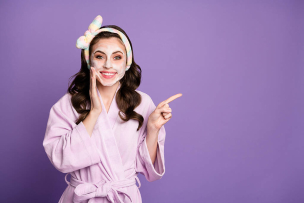 Photo portrait of cute surprised girl with face mask showing empty space smiling with headband isolated on bright purple color background - Fotoğraf, Görsel