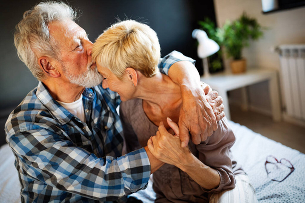 Happy smiling senior couple in love hugging and bonding with true emotions at home - Photo, image