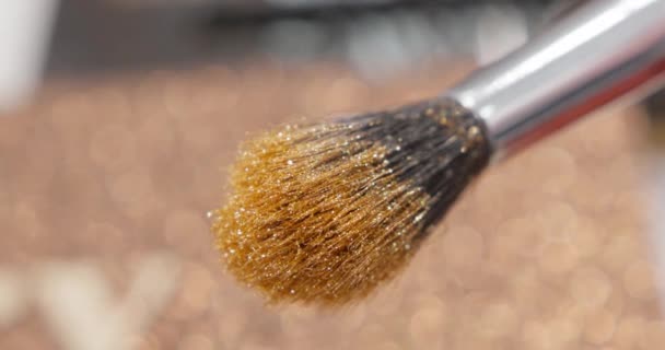 Brush gains glitter to be used in make-up. Macro view of working process, tools in beauty industry. Fashion glamour shiny glitter concept. - Кадры, видео