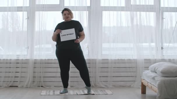 Concepto positividad corporal - una mujer regordeta sostiene un signo con la inscripción I LOVE MYSELF - Imágenes, Vídeo