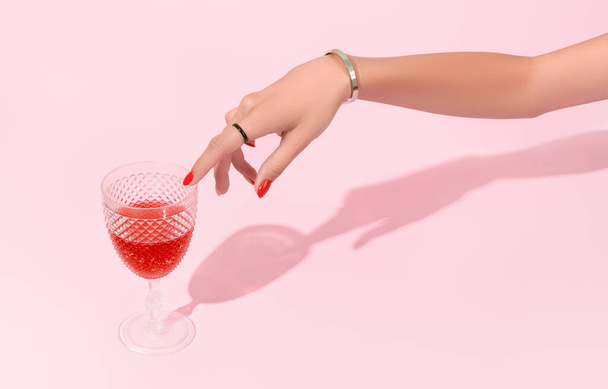 Femmes main toucher verre sur fond rose. Tendances du design de manucure - Photo, image
