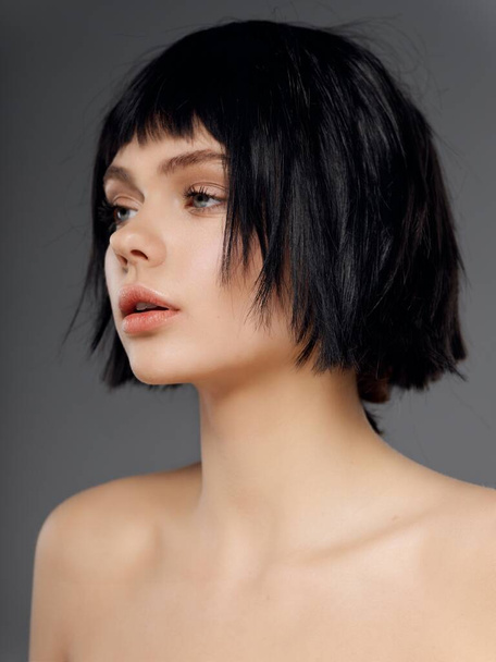 woman with short black hairstyle naked shoulders pretty face gray background portrait - Фото, зображення