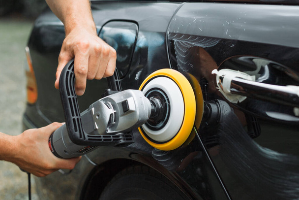 Polishing a used car with an electrical orbital buffer or polisher - Foto, Imagem