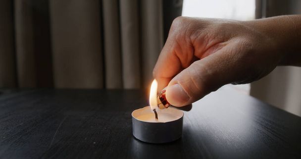Ignite candle with lighter on table - Фото, изображение