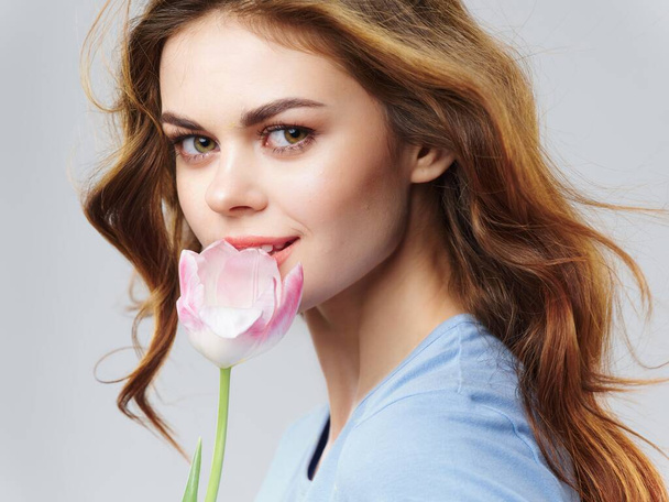 beautiful woman with pink flower in hand portrait 8 march gifts holidays - Foto, afbeelding