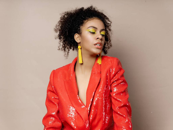 fashionable african woman with yellow earrings and red jacket disco party - Foto, Imagen