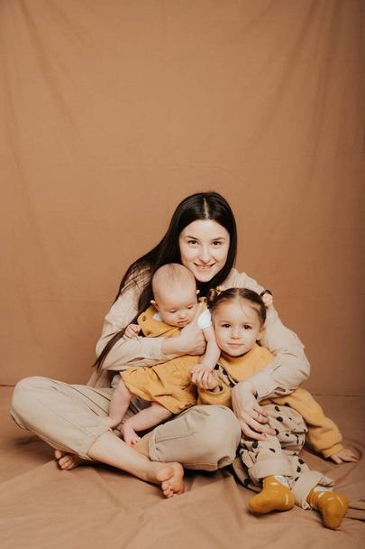 mother and her two children at a photo shoot in the studio - Foto, Bild