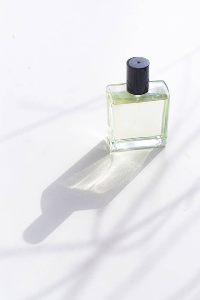 Perfume on a white background with shadows . The choice of perfume. Aromatherapy. Smell. A bottle of perfume. White background. Light and shadows . Copy space - Valokuva, kuva