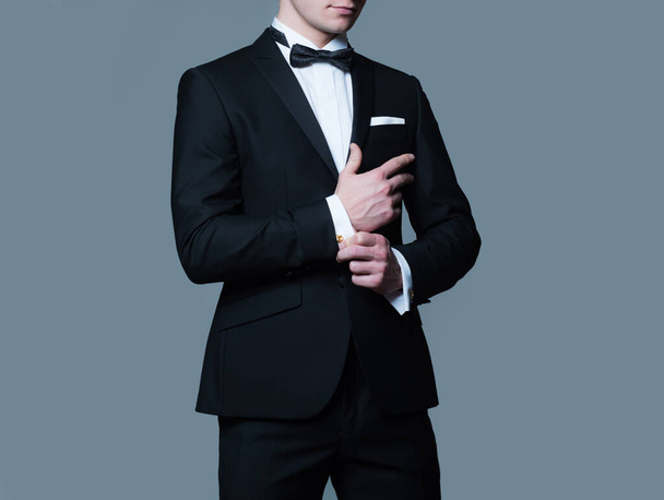 Formal classic suit. Business style outfit. Retro suit fashion. Handsome businessman adjusting his sleeves. - Foto, Bild
