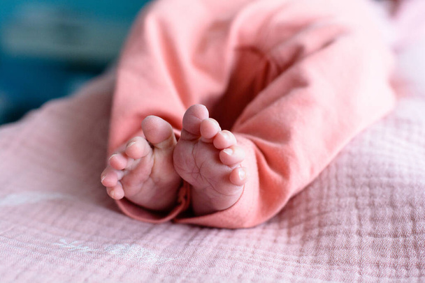 Cute newborn baby feet with little toes in a selective focus - Fotó, kép