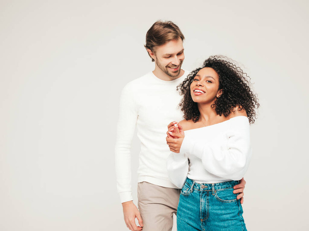 Smiling beautiful woman and her handsome boyfriend. Happy cheerful multiracial family having tender moments on grey background  in studio. Multiethnic models hugging. Embracing each other.Love concept - Zdjęcie, obraz