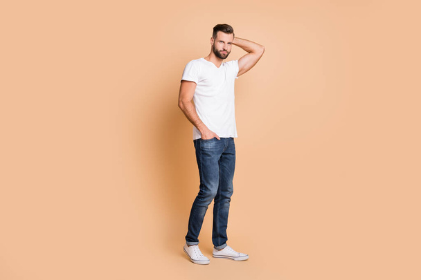 Full length body size view of attractive content macho guy posing wearing cozy clothes isolated over beige pastel color background - Fotografie, Obrázek
