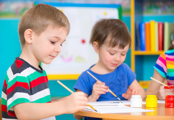 Cute children drawing with colorful paints at kindergarten - Fotó, kép