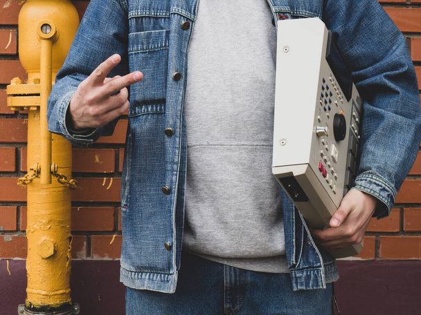 Uma velha máquina de bateria dos anos 90 nas mãos de um batedor contra uma parede de tijolos. Instrumento Musical Digital Retro para Produtores e Beatmakers Hip Hop - Foto, Imagem